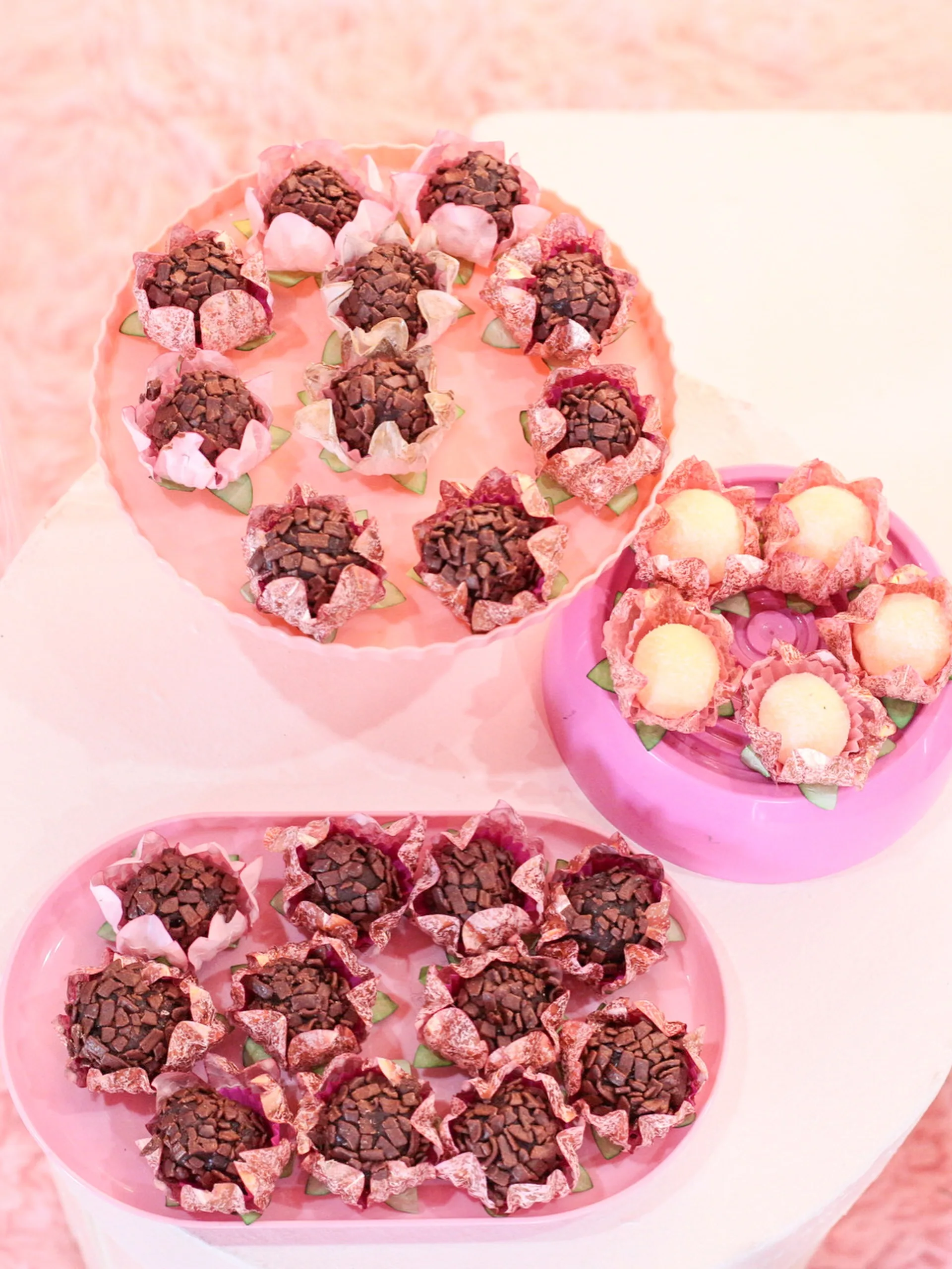 Doces da festa de 15 anos em bandejas rosa.